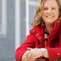 OB-Kandidatin Katharina Schrader im Halbprofil in roter Jacke freundlich lächelnd